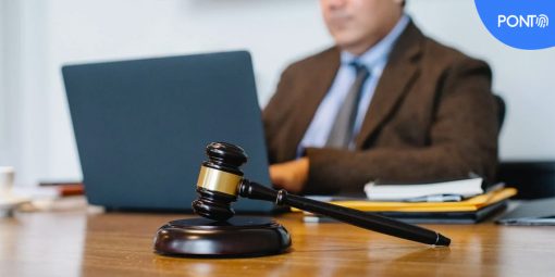 Homem de terno e gravata mexendo no notebook em um escritório de advocacia