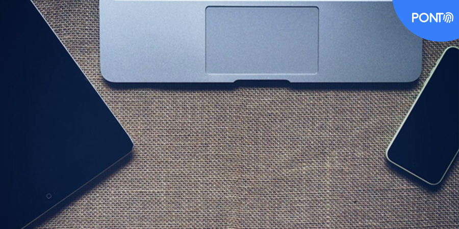 Imagem de um tablet, um notebook e um celular em cima de uma mesa. 